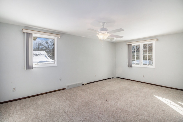 carpeted spare room with ceiling fan