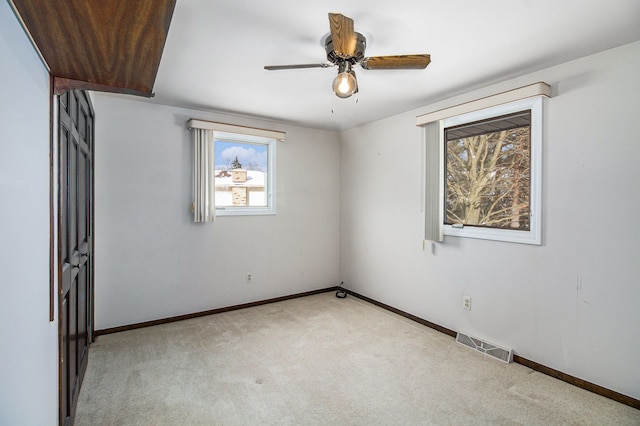 empty room featuring light carpet and ceiling fan