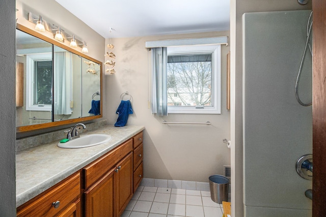 bathroom with a shower, tile patterned flooring, and vanity