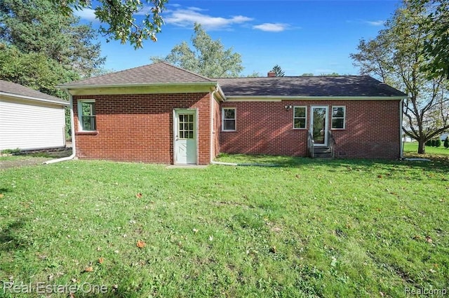 rear view of property with a lawn