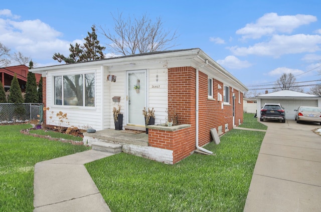 view of front of house featuring a garage, a front yard, and an outbuilding