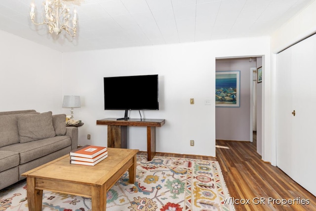 living room featuring a notable chandelier and dark hardwood / wood-style floors