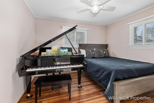 bedroom with wood-type flooring, multiple windows, and ceiling fan