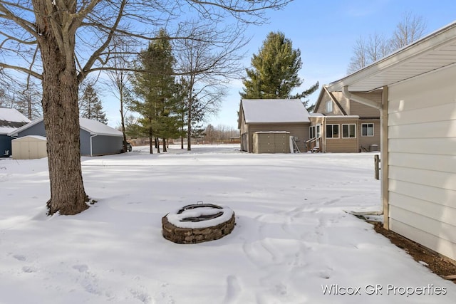 yard layered in snow with a storage unit