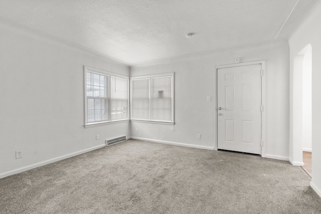 empty room featuring a textured ceiling and carpet flooring