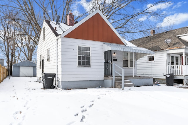 view of front of house with a garage and an outbuilding