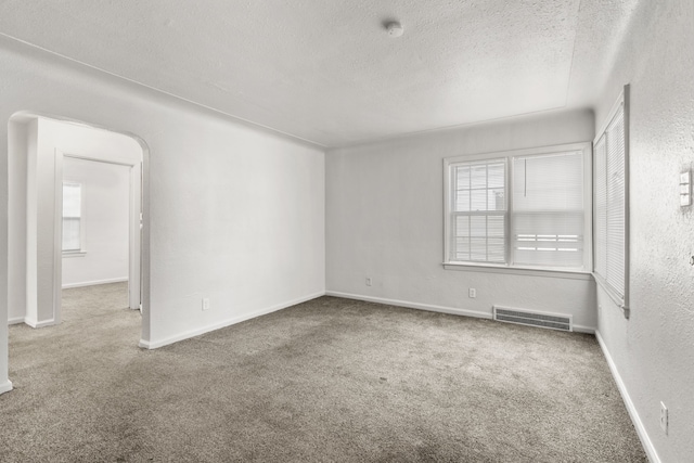 empty room with carpet and a textured ceiling