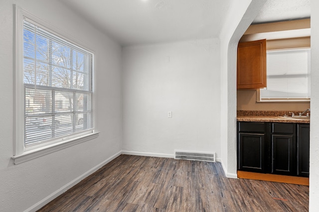 unfurnished dining area with dark wood-type flooring and sink