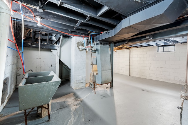 basement featuring heating unit and sink