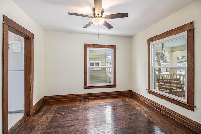 empty room with ceiling fan and dark wood-type flooring