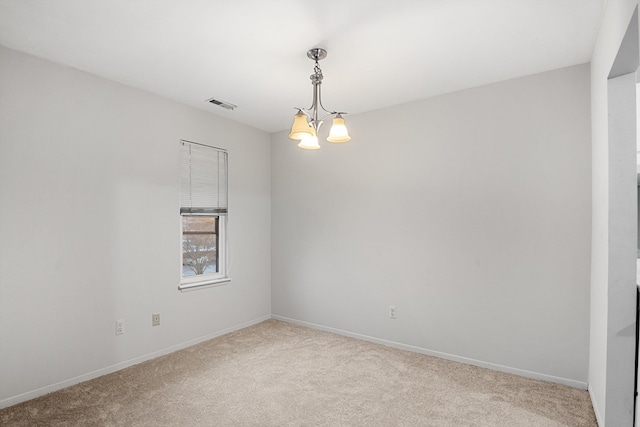 spare room with light carpet and an inviting chandelier