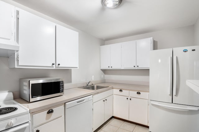 kitchen with sink, premium range hood, white cabinets, light tile patterned floors, and white appliances