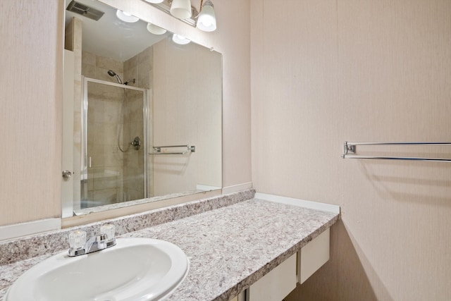 bathroom with vanity and a shower with shower door