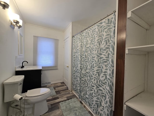 bathroom featuring toilet, vanity, crown molding, and hardwood / wood-style flooring