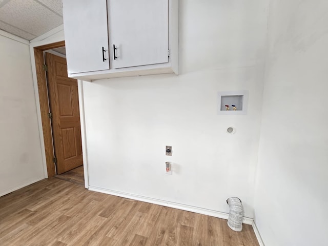 laundry room featuring light hardwood / wood-style floors, hookup for a washing machine, electric dryer hookup, and cabinets