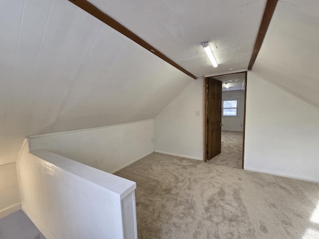 additional living space featuring lofted ceiling and light colored carpet