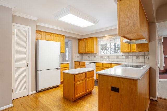 kitchen featuring crown molding, decorative backsplash, white appliances, and a center island