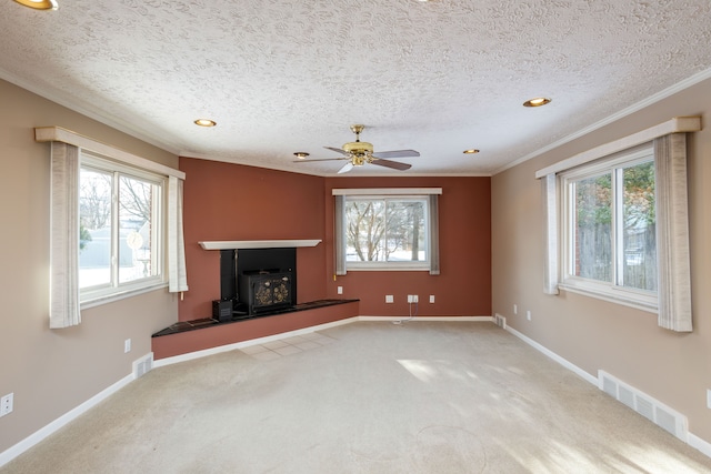 unfurnished living room featuring ceiling fan, a textured ceiling, crown molding, and carpet