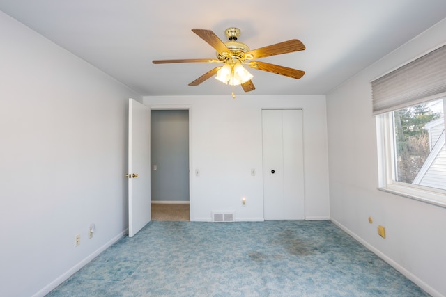 unfurnished bedroom with ceiling fan, a closet, and carpet