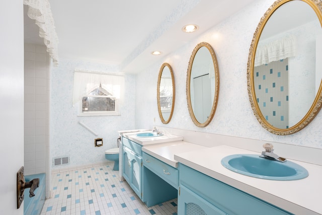 bathroom with toilet, vanity, and tile patterned flooring