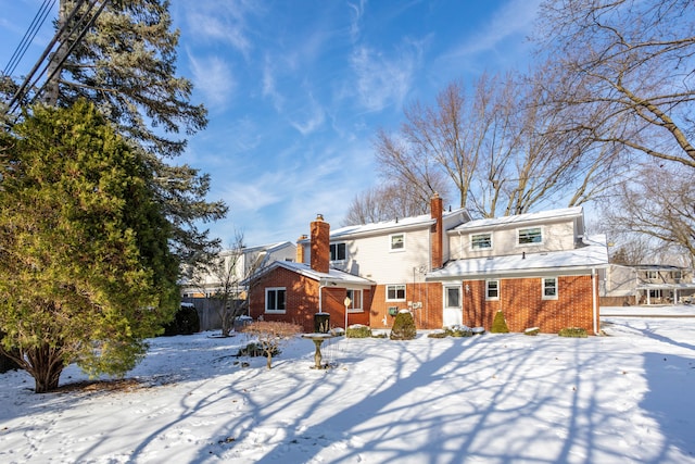 view of snow covered rear of property