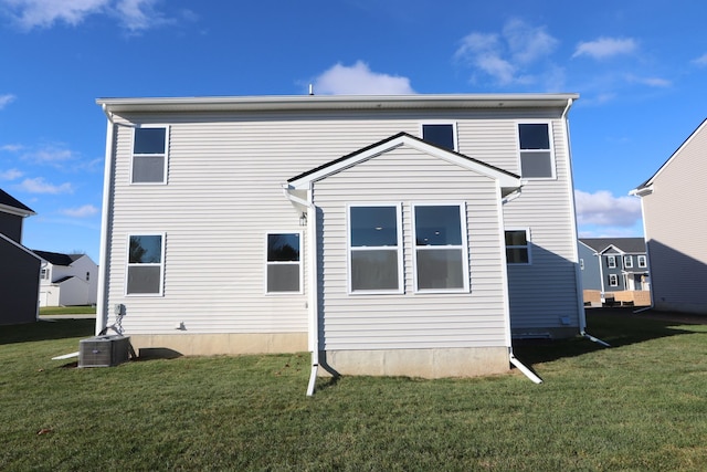 back of property with cooling unit and a yard