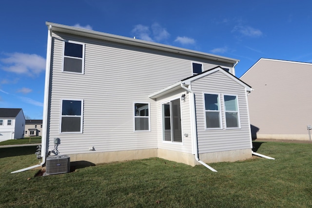 rear view of property featuring cooling unit and a yard