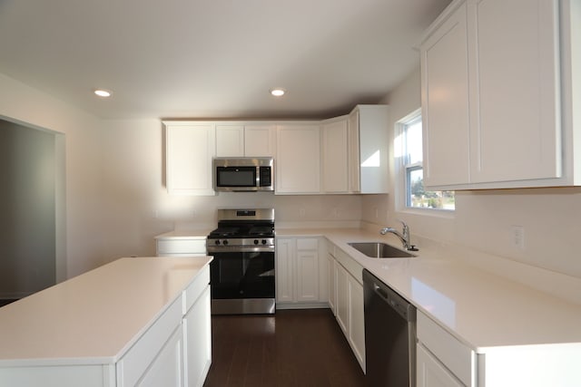 kitchen with appliances with stainless steel finishes, sink, and white cabinetry