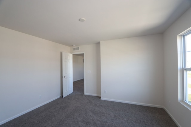 carpeted spare room featuring a wealth of natural light