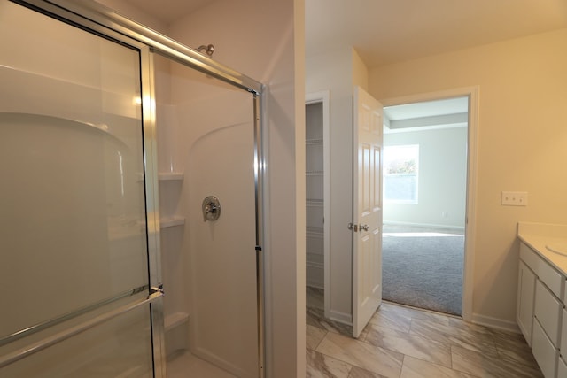 bathroom featuring walk in shower and vanity