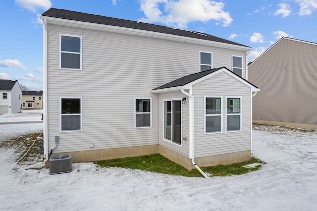 snow covered house with central air condition unit