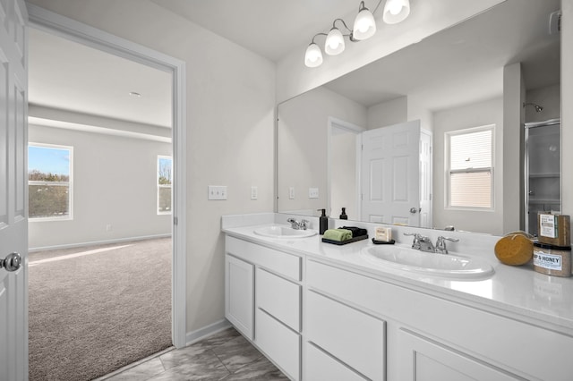 bathroom featuring vanity, a shower with door, and a wealth of natural light