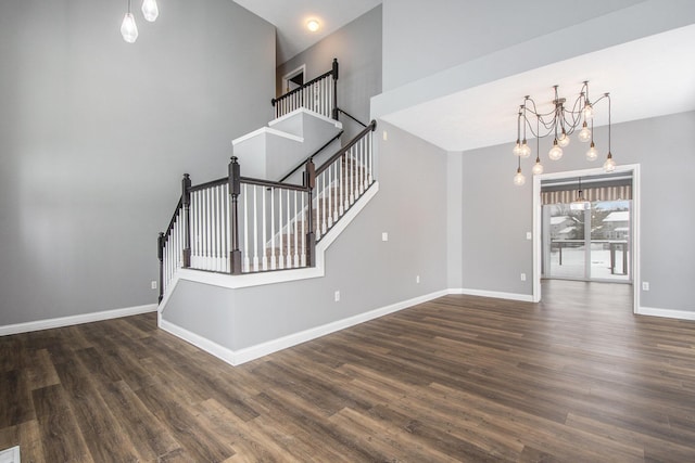 interior space featuring a chandelier, wood finished floors, and baseboards