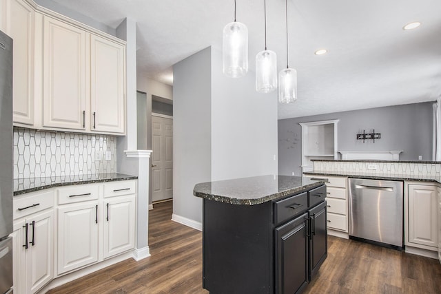 kitchen with tasteful backsplash, dark stone counters, dark wood-type flooring, a center island, and stainless steel dishwasher