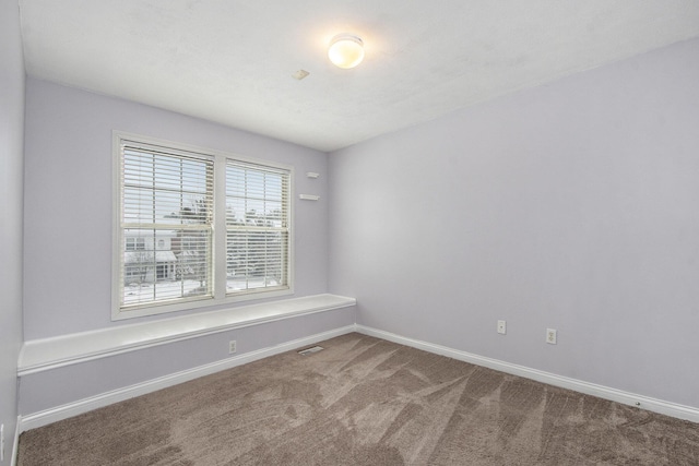 unfurnished room featuring carpet flooring, visible vents, and baseboards