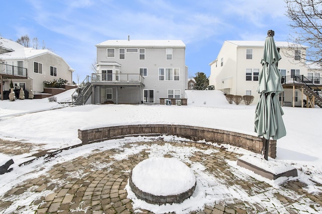 snow covered house featuring stairway