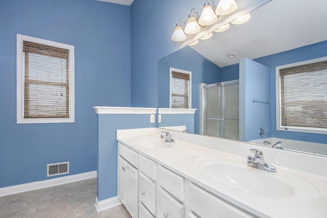 full bathroom featuring a stall shower, baseboards, visible vents, and a sink