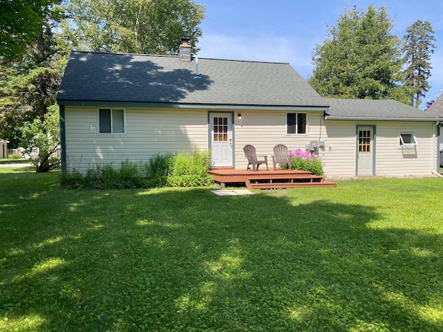 back of property featuring a lawn and a deck