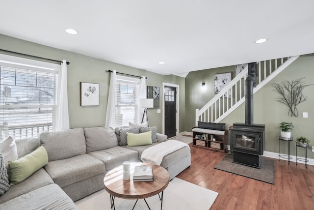 living room with a wood stove and wood-type flooring