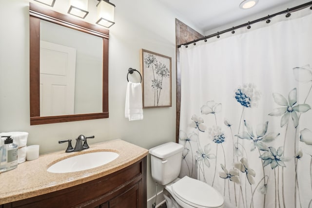 bathroom with walk in shower, vanity, and toilet