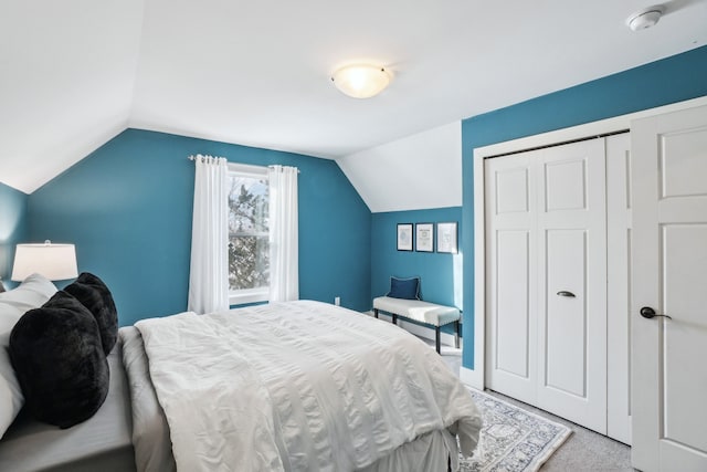 carpeted bedroom featuring a closet and vaulted ceiling