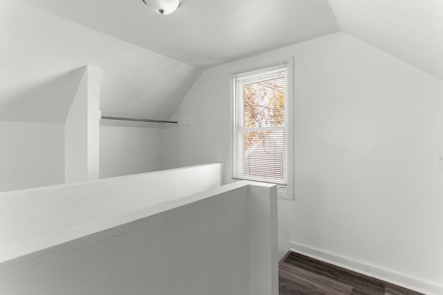 additional living space with dark wood-type flooring and lofted ceiling