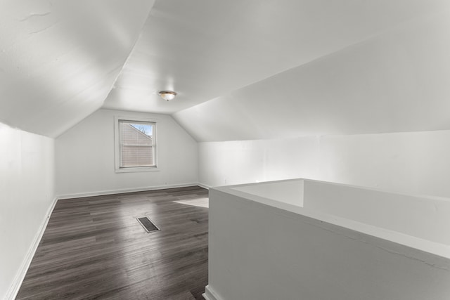 additional living space with lofted ceiling and dark hardwood / wood-style floors