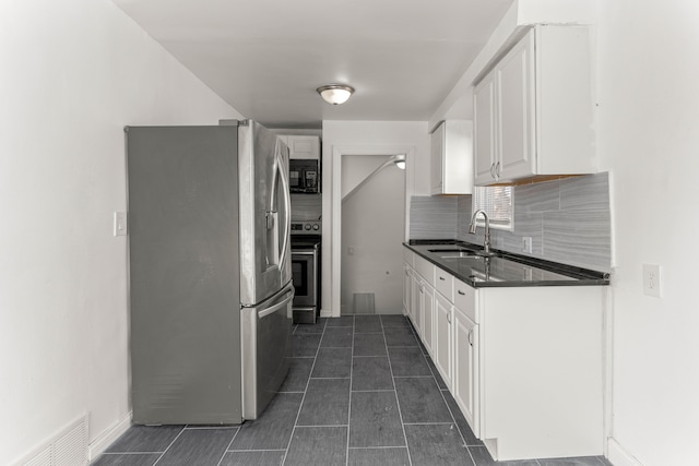 kitchen with appliances with stainless steel finishes, white cabinets, tasteful backsplash, and sink