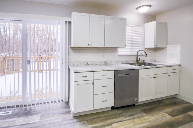 kitchen with tasteful backsplash, dark hardwood / wood-style flooring, stainless steel dishwasher, white cabinets, and sink