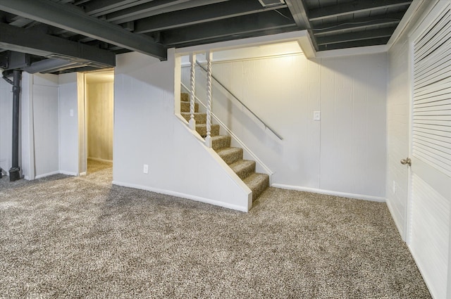 basement featuring carpet and wood walls