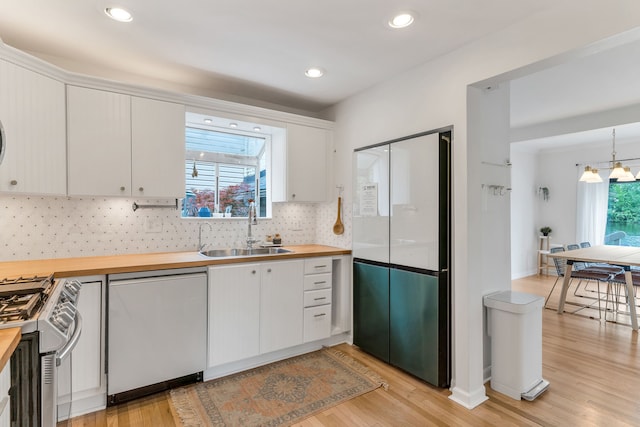 kitchen with white cabinetry, stainless steel range with gas cooktop, sink, and dishwashing machine