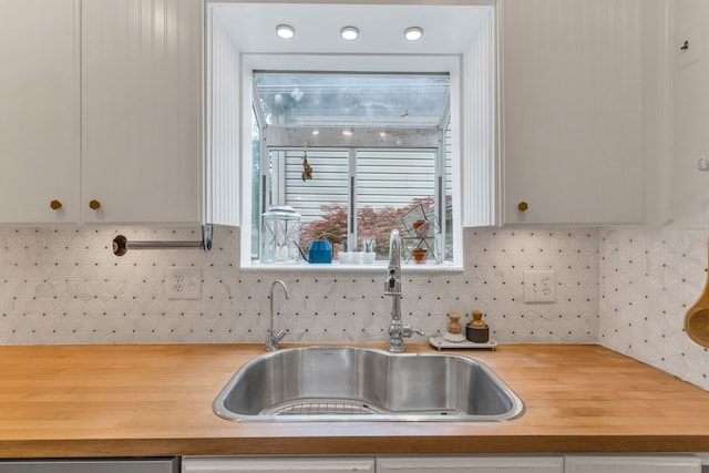 kitchen featuring sink, wood counters, and decorative backsplash