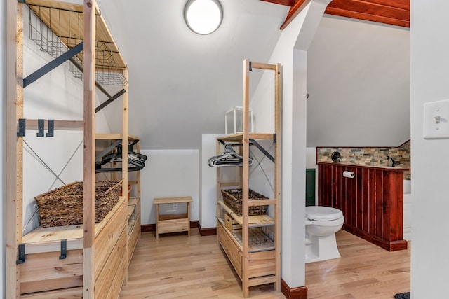 bathroom featuring lofted ceiling, hardwood / wood-style floors, and toilet