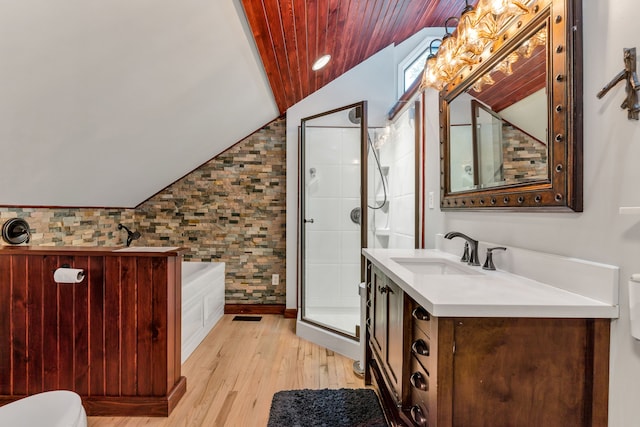 bathroom featuring lofted ceiling, hardwood / wood-style floors, vanity, and separate shower and tub